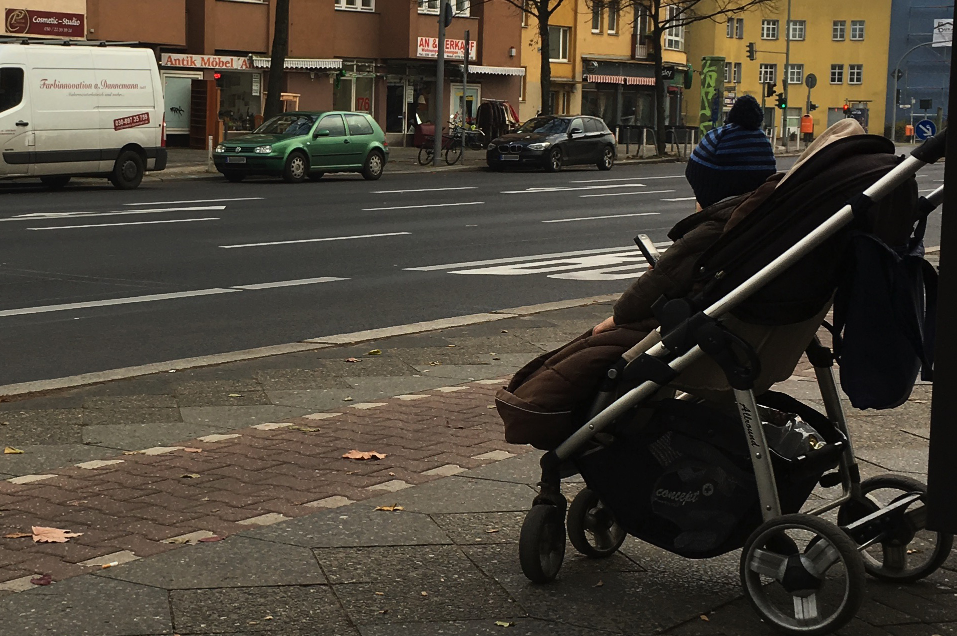 A toddler in a stroller, holding a mobile phone.